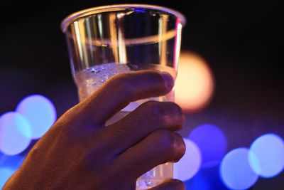 Close-up of hand holding glass against blurred background