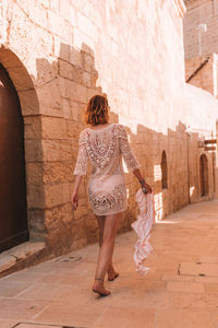 Rear view of woman walking on building