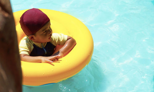 Smiling boy in swimming pool at tourist resort