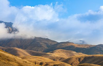 Scenic view of mountains against cloudy sky