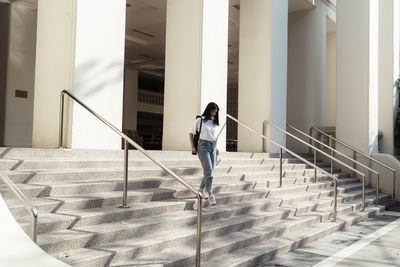 Full length of woman walking on staircase against building