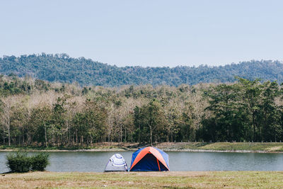 Tent by lake against sky