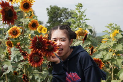 Low angle view of girl standing on sunflower