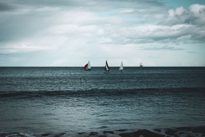 Sailboat in sea against sky