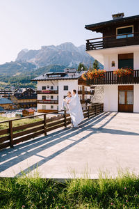 People by buildings against mountain range