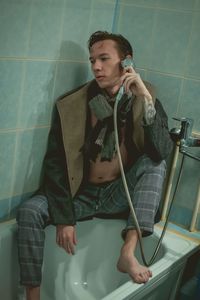 Portrait of a young man sitting in a bath