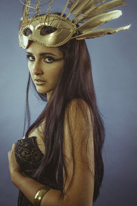 Close-up portrait of young woman against gray background