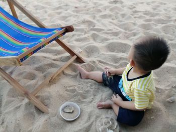 High angle view of girl playing on sand at beach