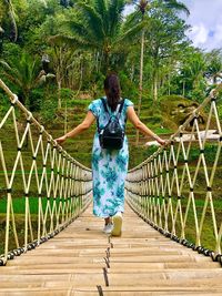 Rear view of woman standing on footbridge