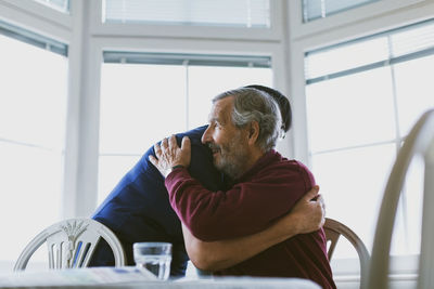 Man looking away while sitting on table