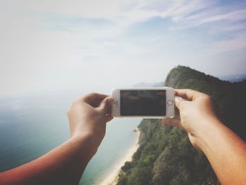 Cropped image of woman photographing through smart phone