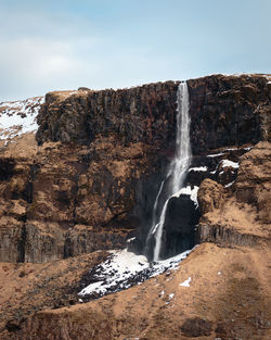 Scenic view of waterfall against sky