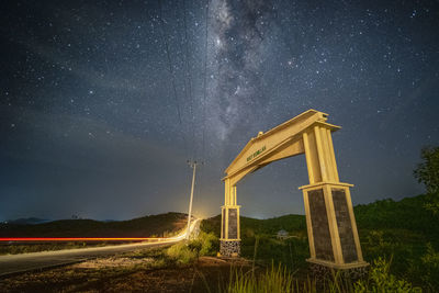 Road amidst field against sky at night