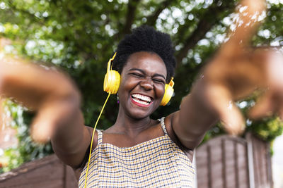 Cheerful woman listening to music through headphones