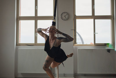 Full length of young woman exercising at home