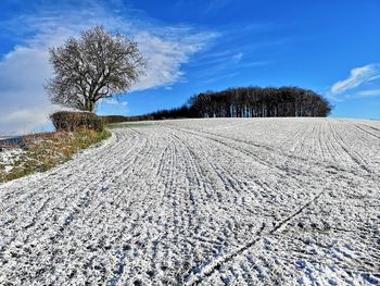 Scenic view of snow covered field against sky