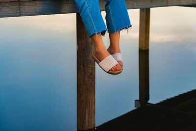 Low section of woman standing against sky