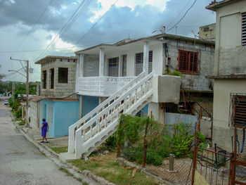 Houses by street against sky in city