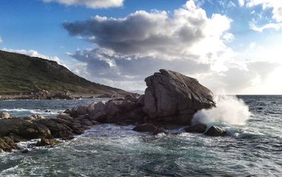 Rocks in sea against sky