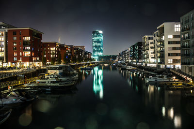 River amidst illuminated buildings in city at night