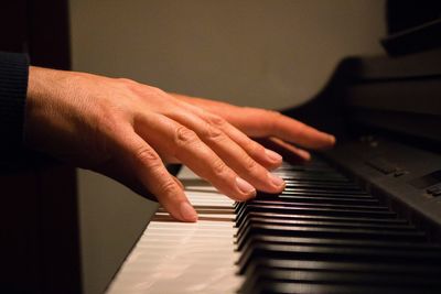 Cropped image of person playing piano