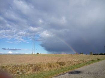 Scenic view of field against rainbow in sky