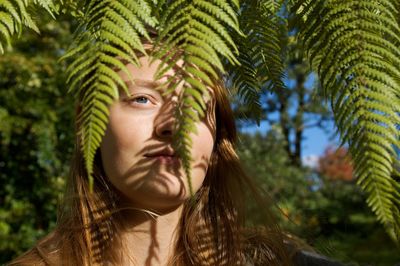 Teenage girl standing by tree