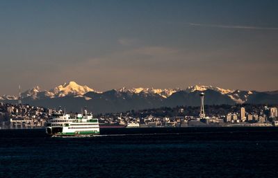 Scenic view of city by sea against sky