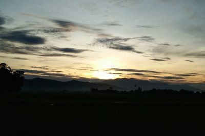 Scenic view of silhouette field against sky at sunset