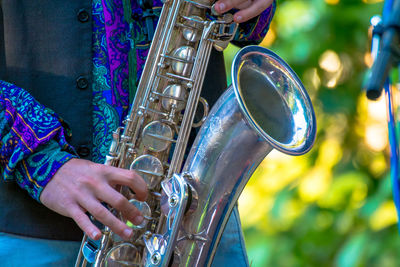 Midsection of man playing saxophone