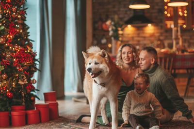 Candid authentic happy family during wintertime together enjoying holidays with dog at xmas