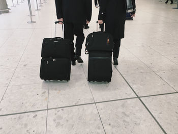 Low section of people carrying luggage at airport