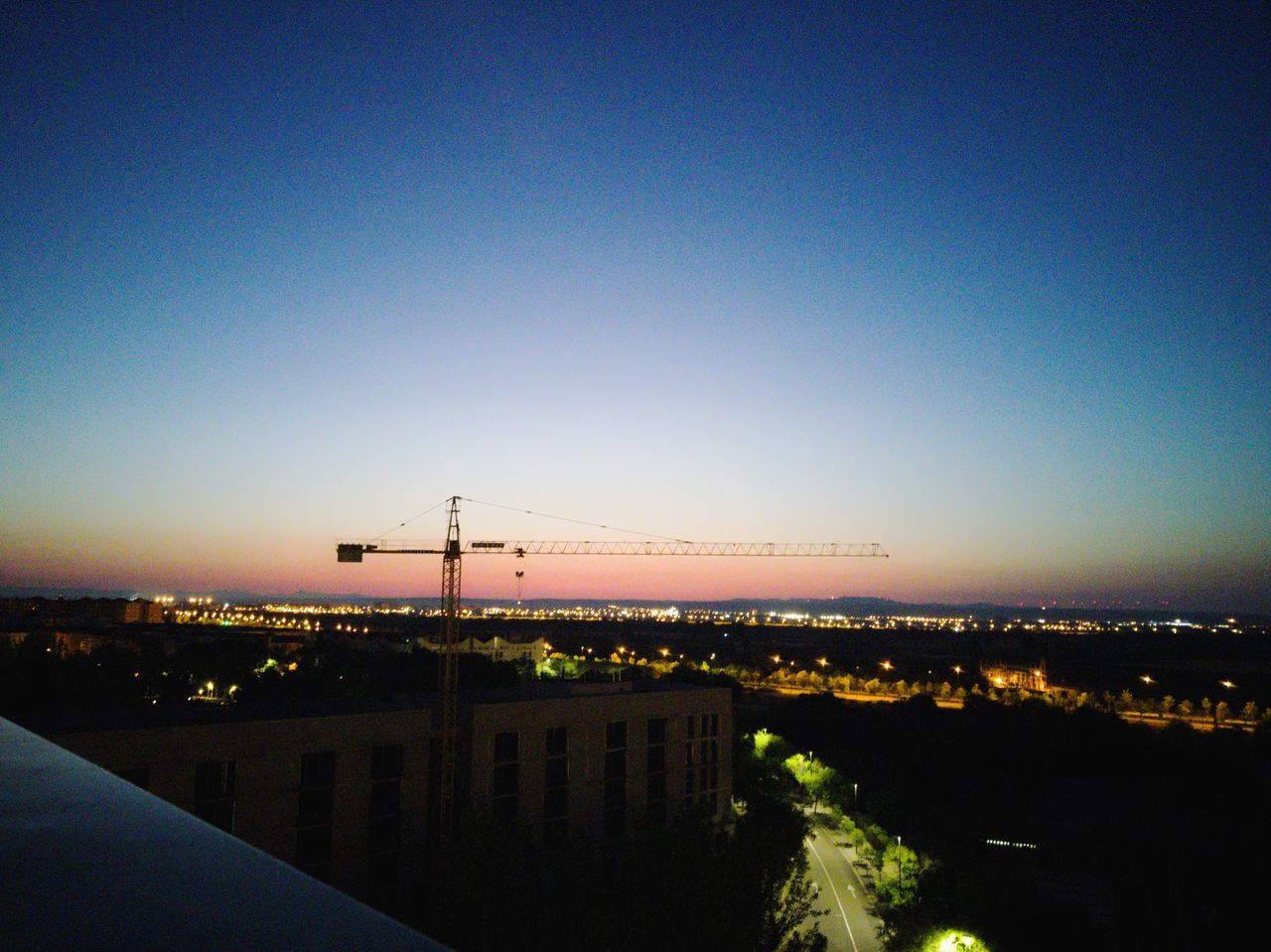 ILLUMINATED BUILDINGS AGAINST CLEAR SKY AT SUNSET