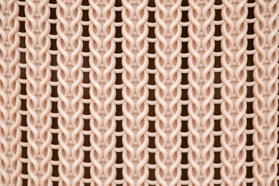 The texture of a yellow plastic wicker basket closeup.
