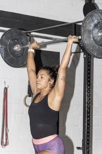 Latin woman working out in a gym lifting weights