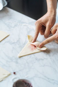 Cook twisting dough into croissant on table