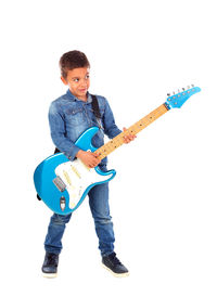 Low angle view of boy playing guitar against white background