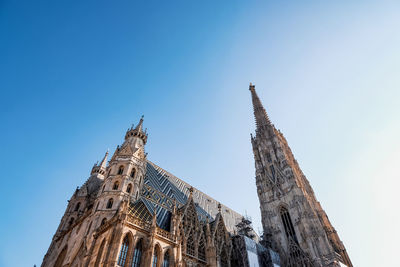 Low angle view of cathedral building against clear blue sky in vienna 