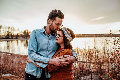 Young couple standing against sky