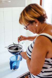 Woman preparing fruit juice at home