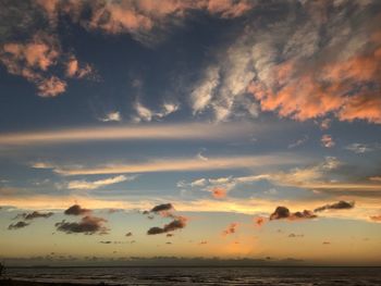 Scenic view of beach against sky at sunset