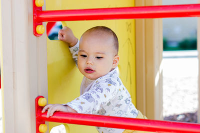Cute little baby boy playing at children playground.