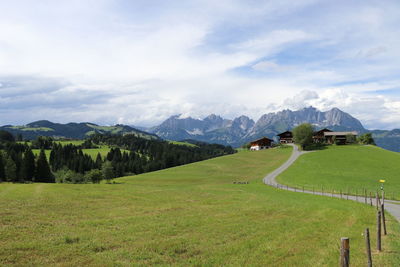 Scenic view of green landscape and mountains against sky