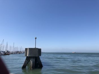 Sailboat in sea against clear blue sky