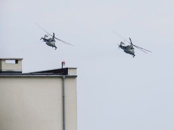 Low angle view of helicopters flying in sky