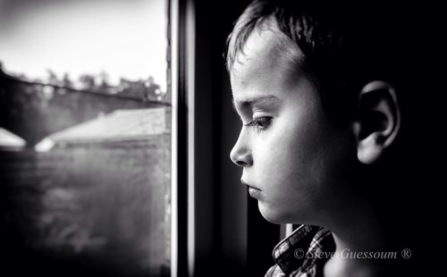 Portrait of boy looking through window