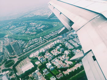 Aerial view of airplane wing over cityscape