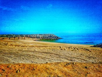 Scenic view of beach against blue sky