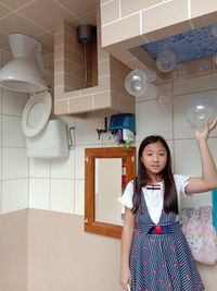 Portrait of smiling girl standing at home