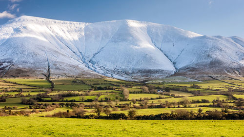 Scenic view of field and mountains against sky